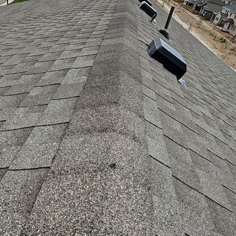 Shingle roof ridge with visible hail damage and vents Shingle roof ridge with visible hail damage and vents