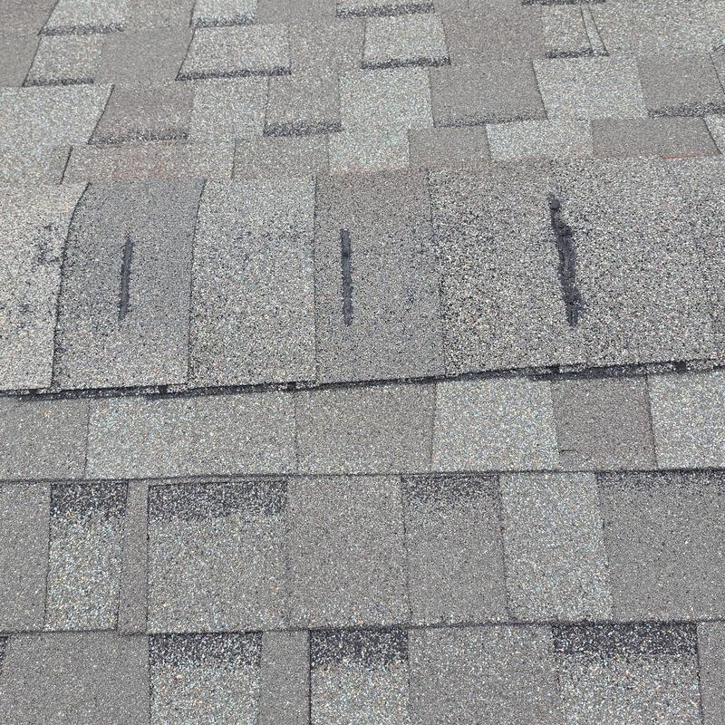 Asphalt roof shingles with hail damage marks