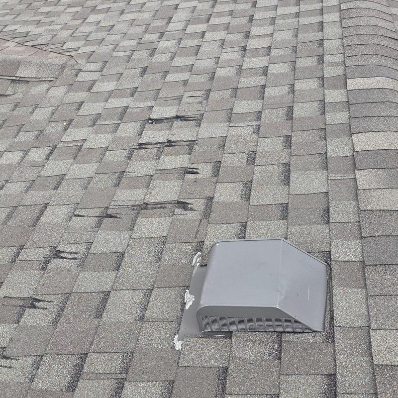 Asphalt shingles with hail damage near roof vent