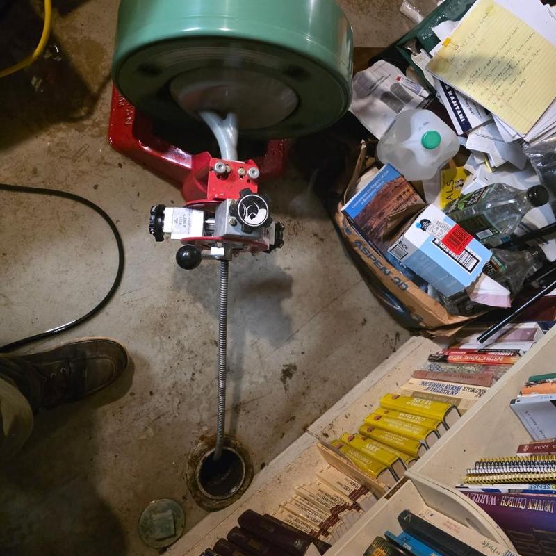 Sewer drain cleaning machine clearing blockage in basement