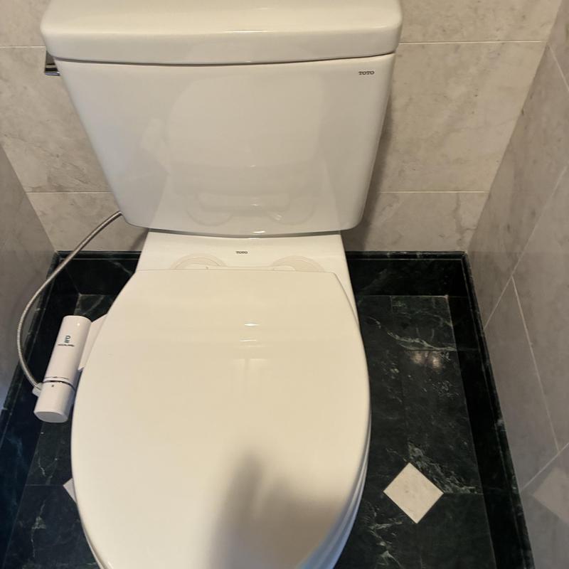 Toto elongated toilet with bidet installed on marble floor