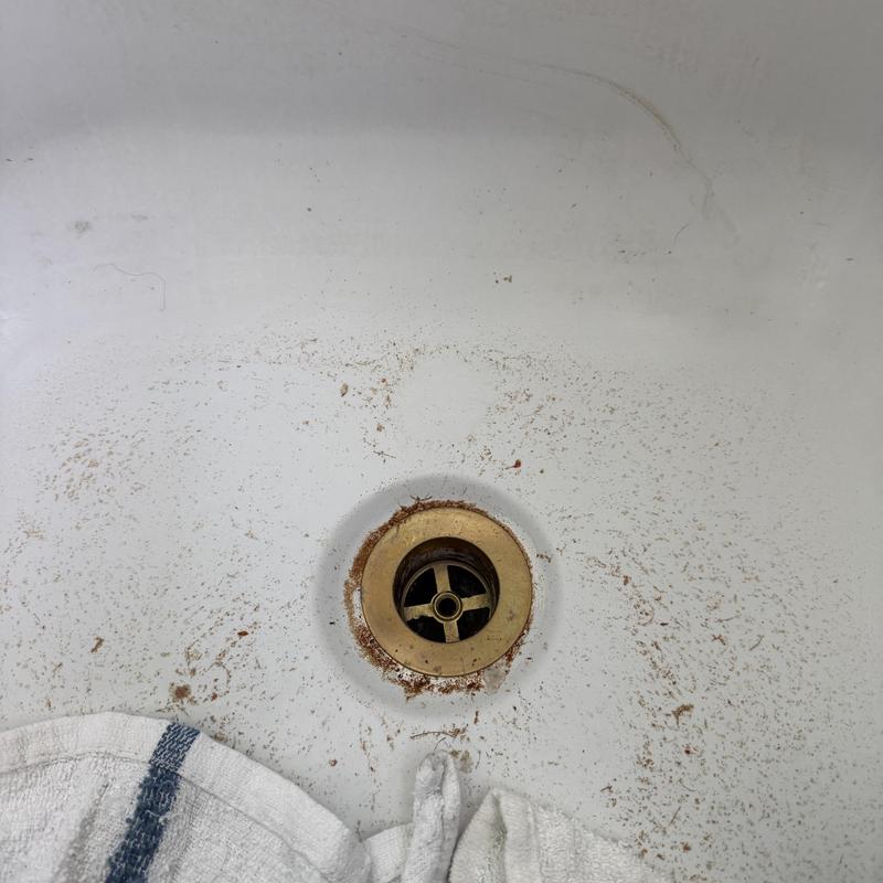 Bathtub drain with rust and dirt around drain hole