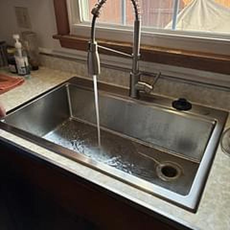 Kitchen sink and faucet with running water