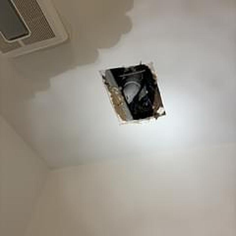 Ceiling cutout showing plumbing pipes for leak detection