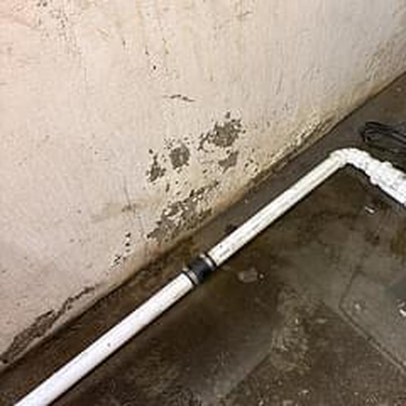 Sump pump discharge pipe with fernco clamp outdoors