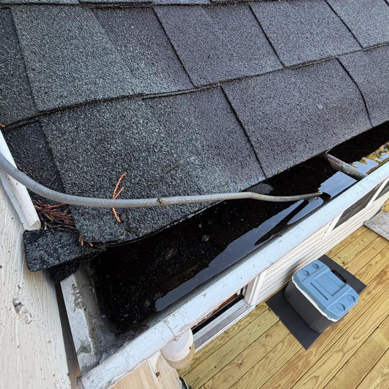 Gutter with standing water and improperly pitched shingles
