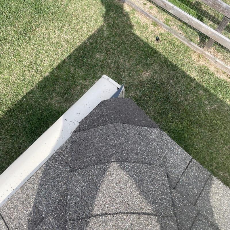 Asphalt shingle roof ridge with white gutter edge