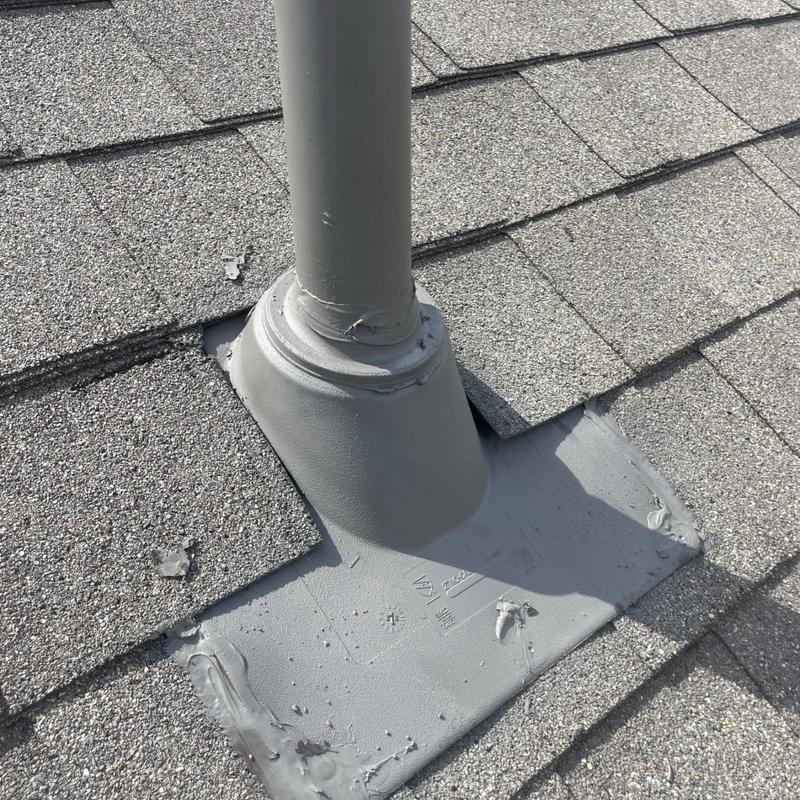 Roof pipe flashing with sealant on asphalt shingles