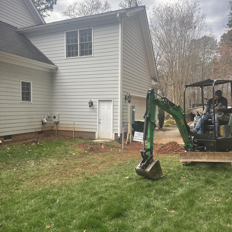 Foundation footing excavation with mini excavator near house