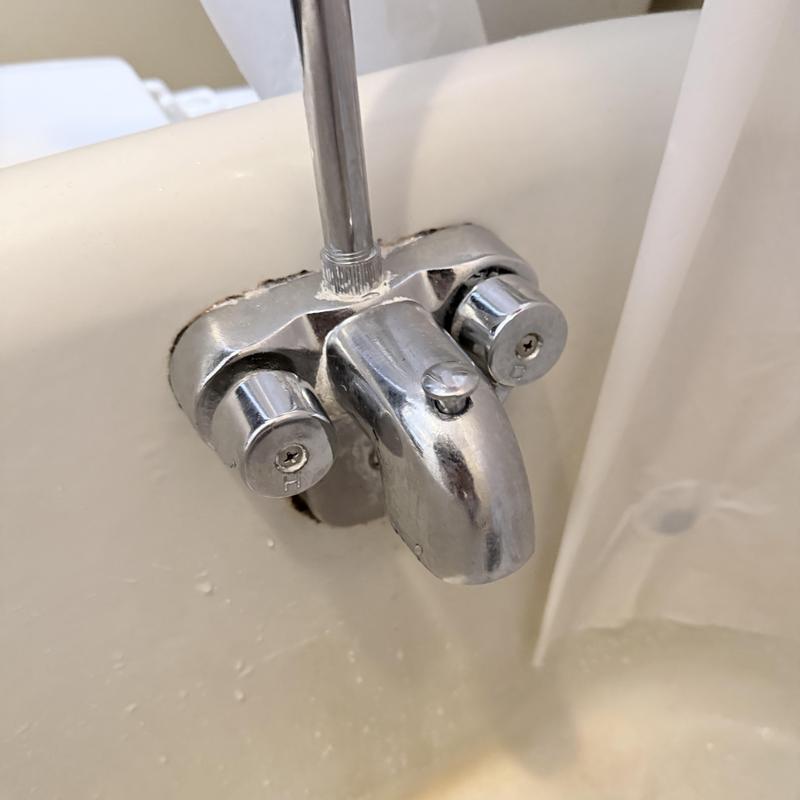 Two-handle tub valve with chrome spout in bathtub Two-handle tub valve with chrome spout in bathtub