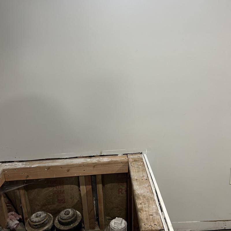 Drywall and wall framing with exposed plumbing access panel Drywall and wall framing with exposed plumbing access panel