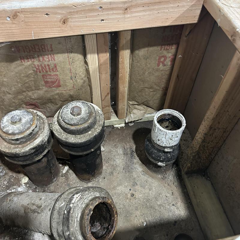 Cast iron drain pipes with coupler in basement floor Cast iron drain pipes with coupler in basement floor