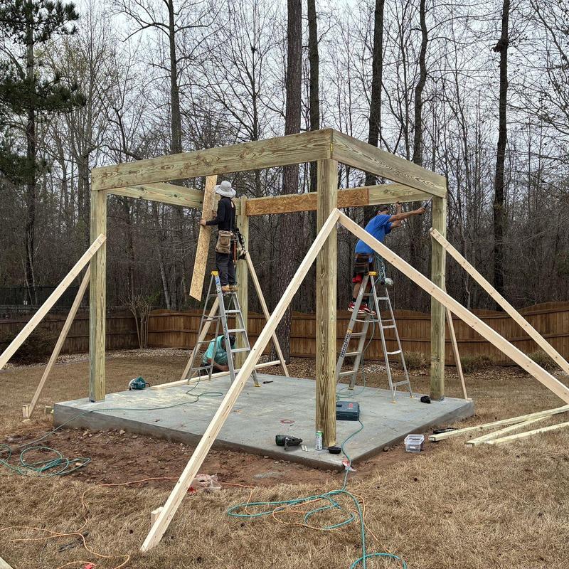 Wooden gazebo frame on concrete foundation with braces