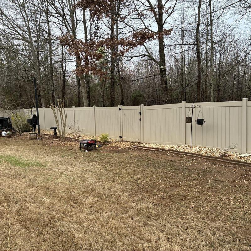 Vinyl privacy fence with gate and rock bed mulch
