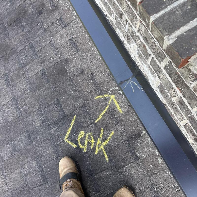Roof shingles with chalk-marked leak near flashing