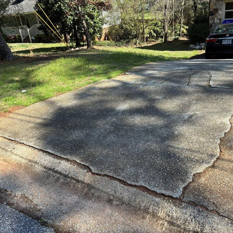 Concrete driveway with large cracks and surface damage