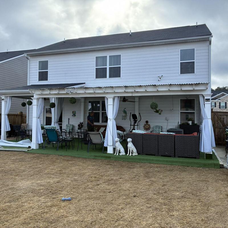 White pergola with translucent corrugated roof and curtains