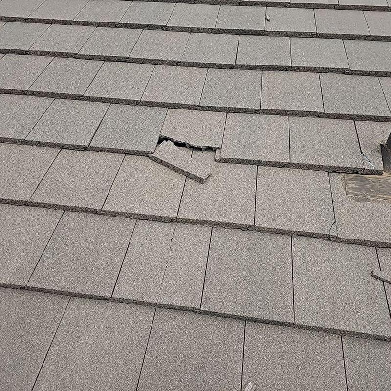Broken tile on gray concrete tile roof Broken tile on gray concrete tile roof