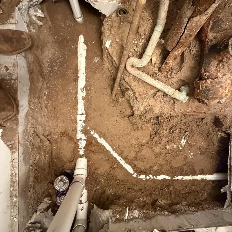 PVC sewer pipes exposed in slab home excavation