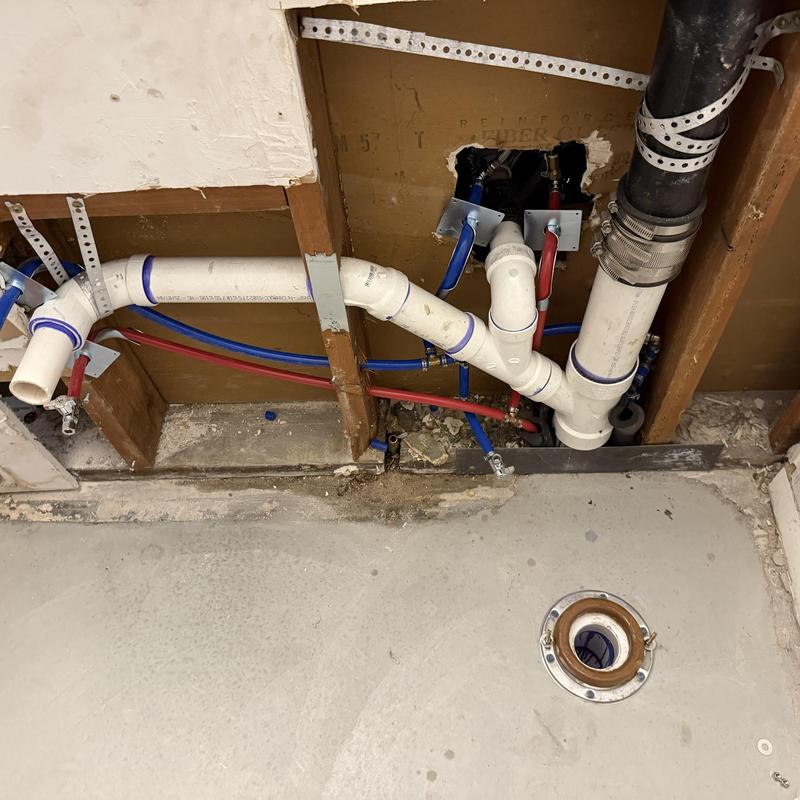 PVC sewer piping and water lines in wall cavity