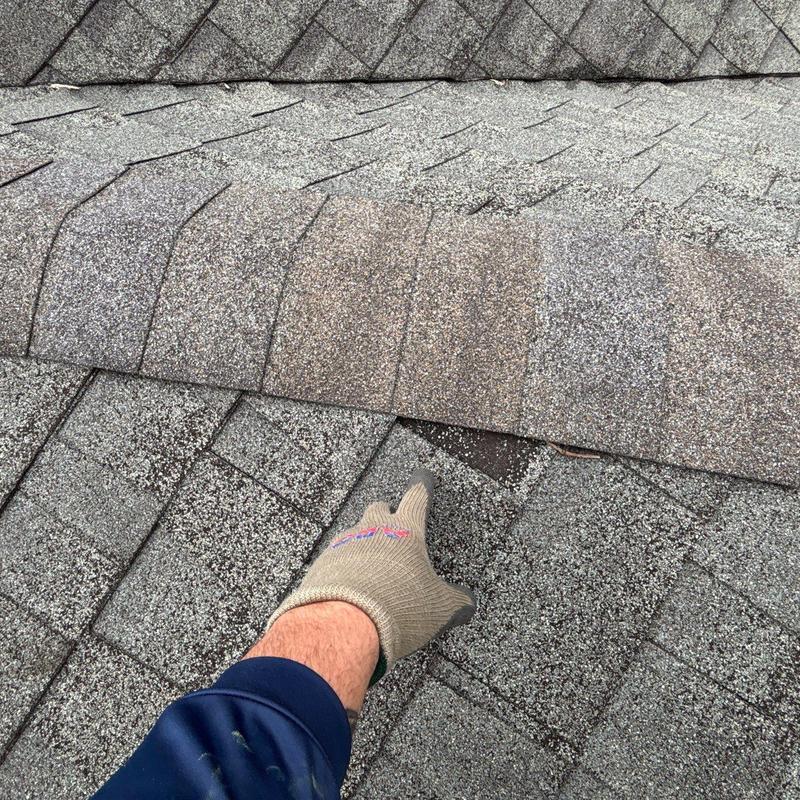 Damaged asphalt shingles with granule loss on roof