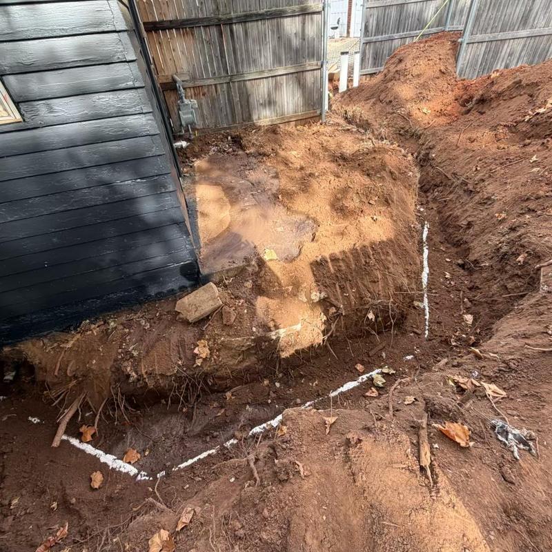 Sewer service line excavation at duplex foundation