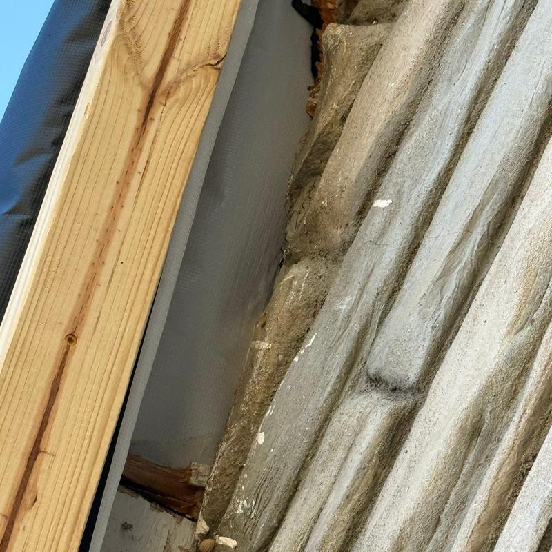 Roof underlayment installation with wood framing and stone wall