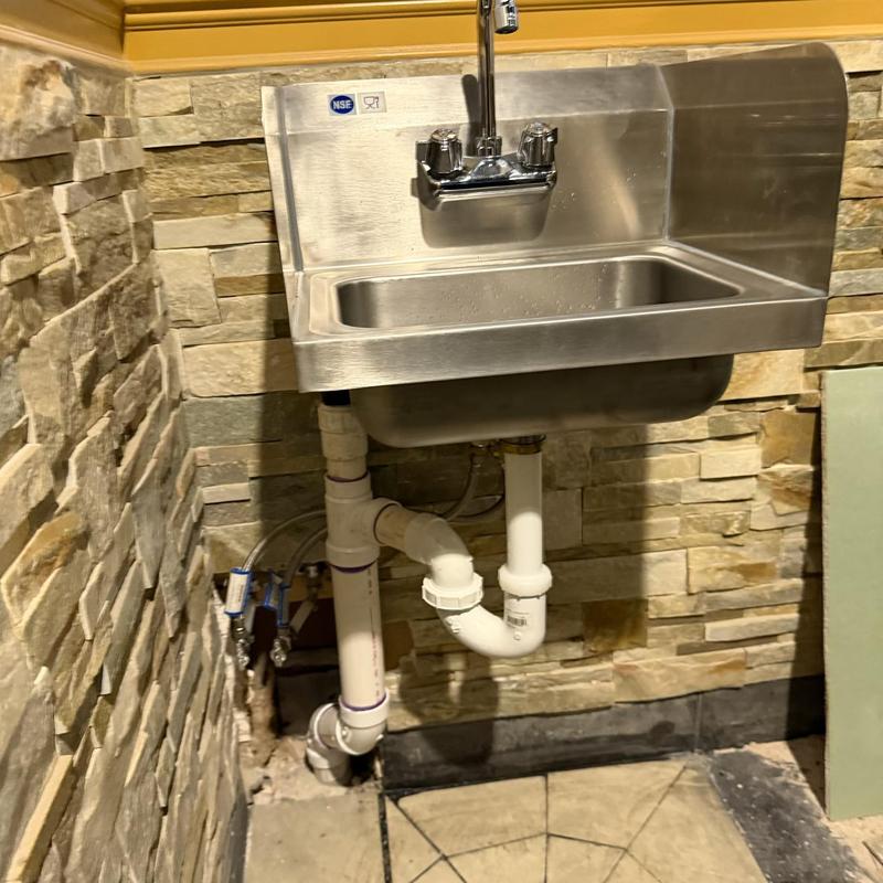 Commercial stainless steel sink with plumbing installation