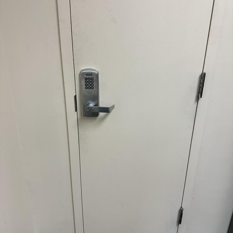 Commercial keypad lock on white door with handle