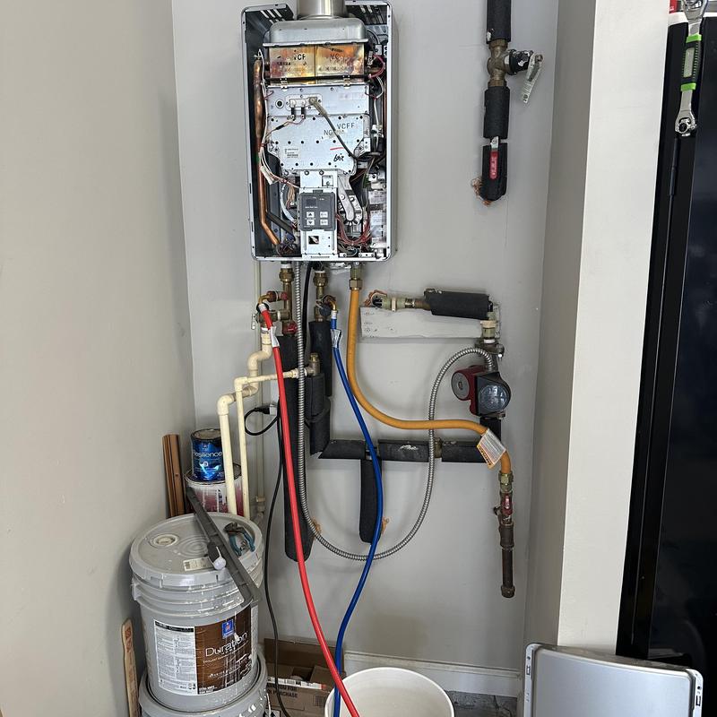Tankless water heater with flush setup in utility space