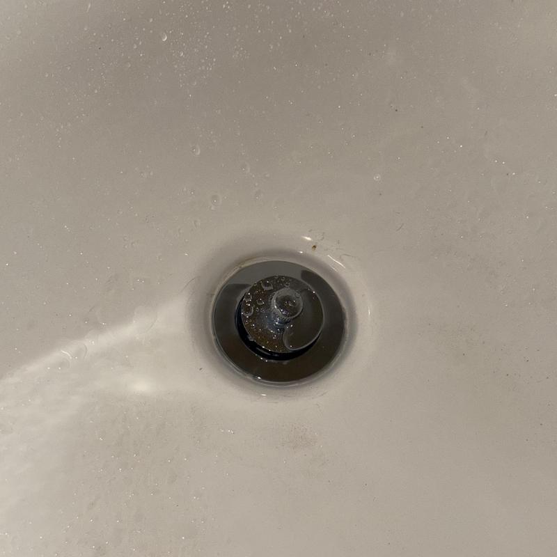 Bath tub strainer with water flow in white tub