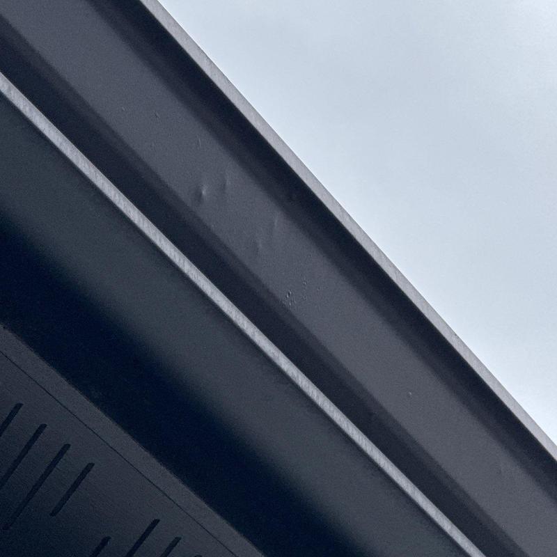 Metal gutter with hail damage dents close-up