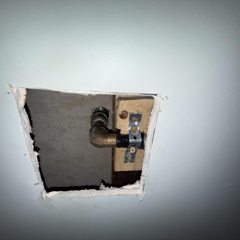 Shower valve pipe and mounting bracket inside wall cavity