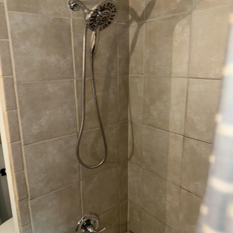 Chrome shower trim kit in tiled shower corner