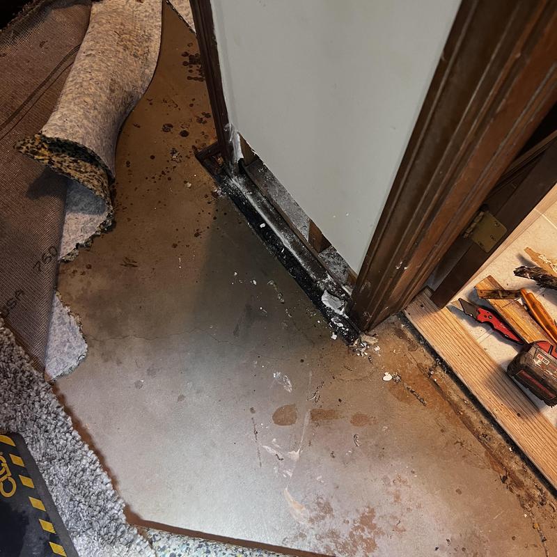 Concrete subfloor with moisture damage near doorway