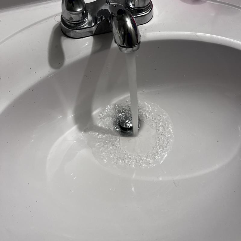 Bathroom sink drain clearing with running water