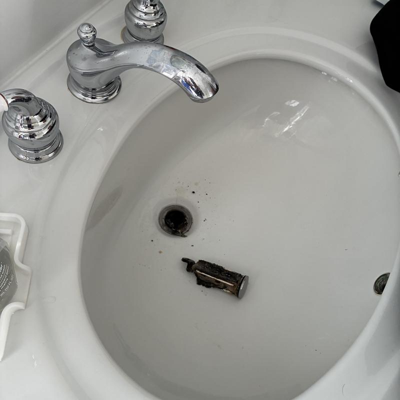 Bathroom sink drain clog removal with debris cleared