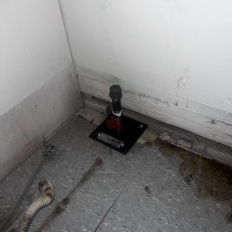 Gas pipe installation baseplate in utility room corner