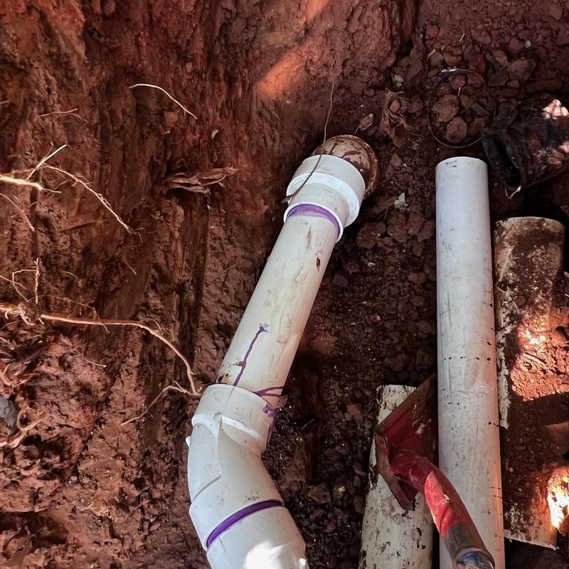 PVC sewer service line installation in dirt trench