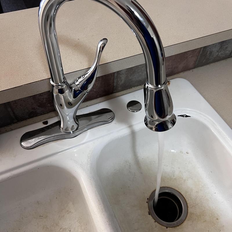 Delta kitchen faucet with running water in sink
