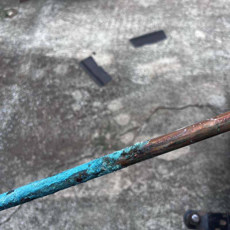 Copper water line with corrosion buildup and damage