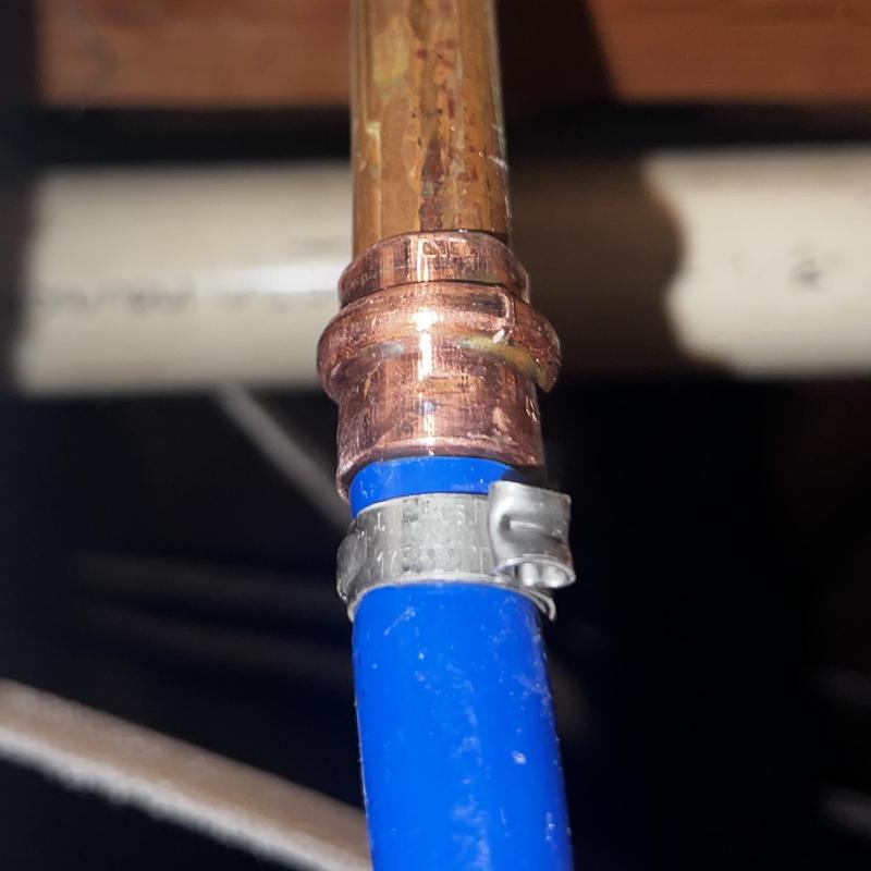 Copper pipe and blue PEX connection with clamp