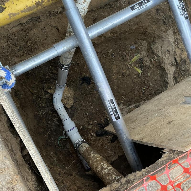 PVC sewer line with replaced fittings in excavation site