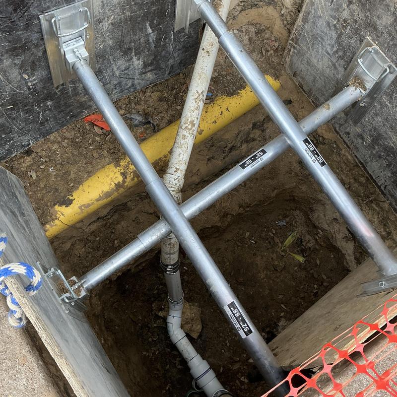 PVC sewer line with bracing and soil trench