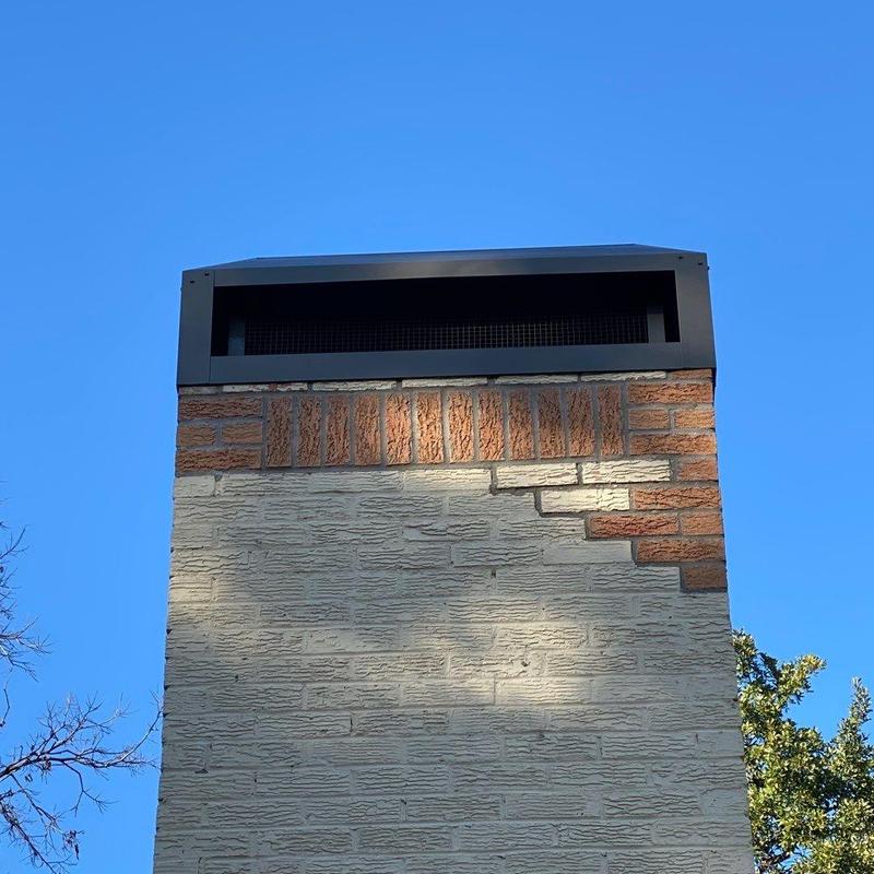 Brick chimney with new black metal chimney cover Brick chimney with new black metal chimney cover