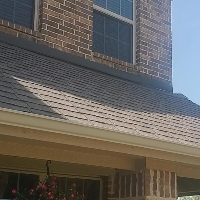 Asphalt shingle roof with hail damage near windows