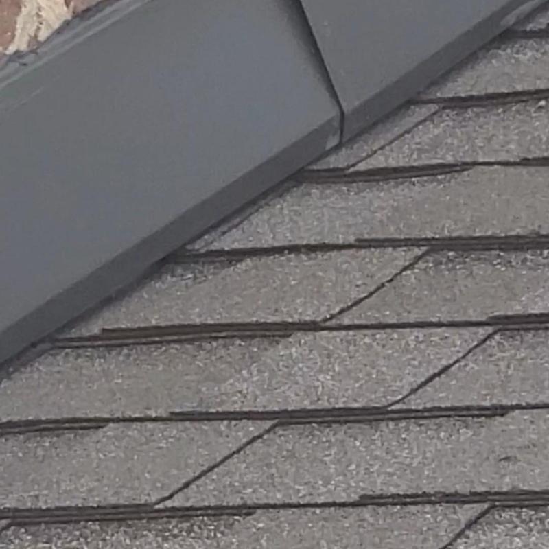 Asphalt shingle roof with wind and hail damage close-up
