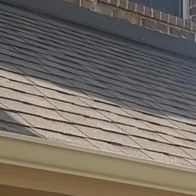 Asphalt shingle roof with wind and hail damage