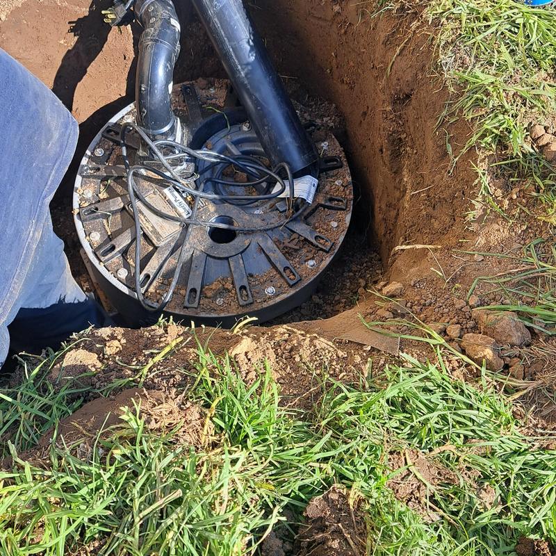 Sewer ejector pump basin in yard trench installation