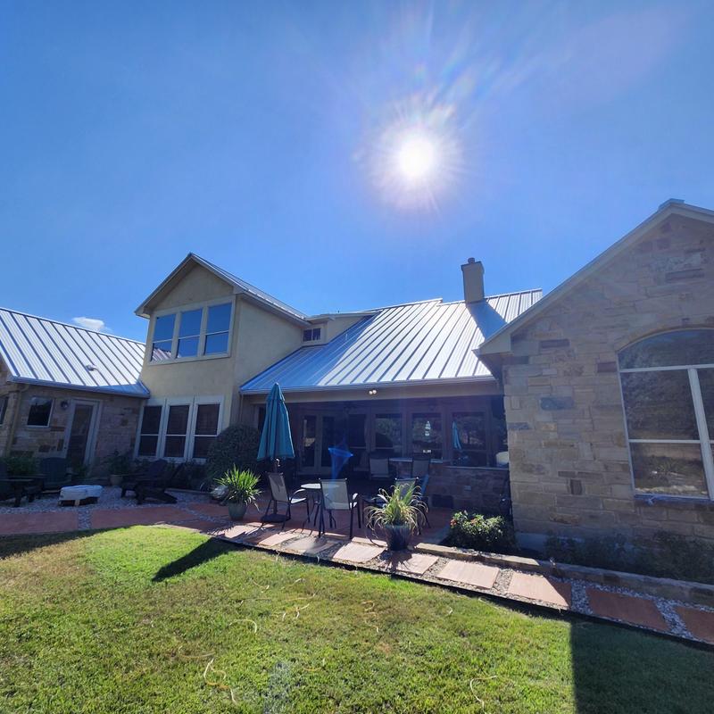 Standing seam metal roof with chimney cover and gutters Standing seam metal roof with chimney cover and gutters